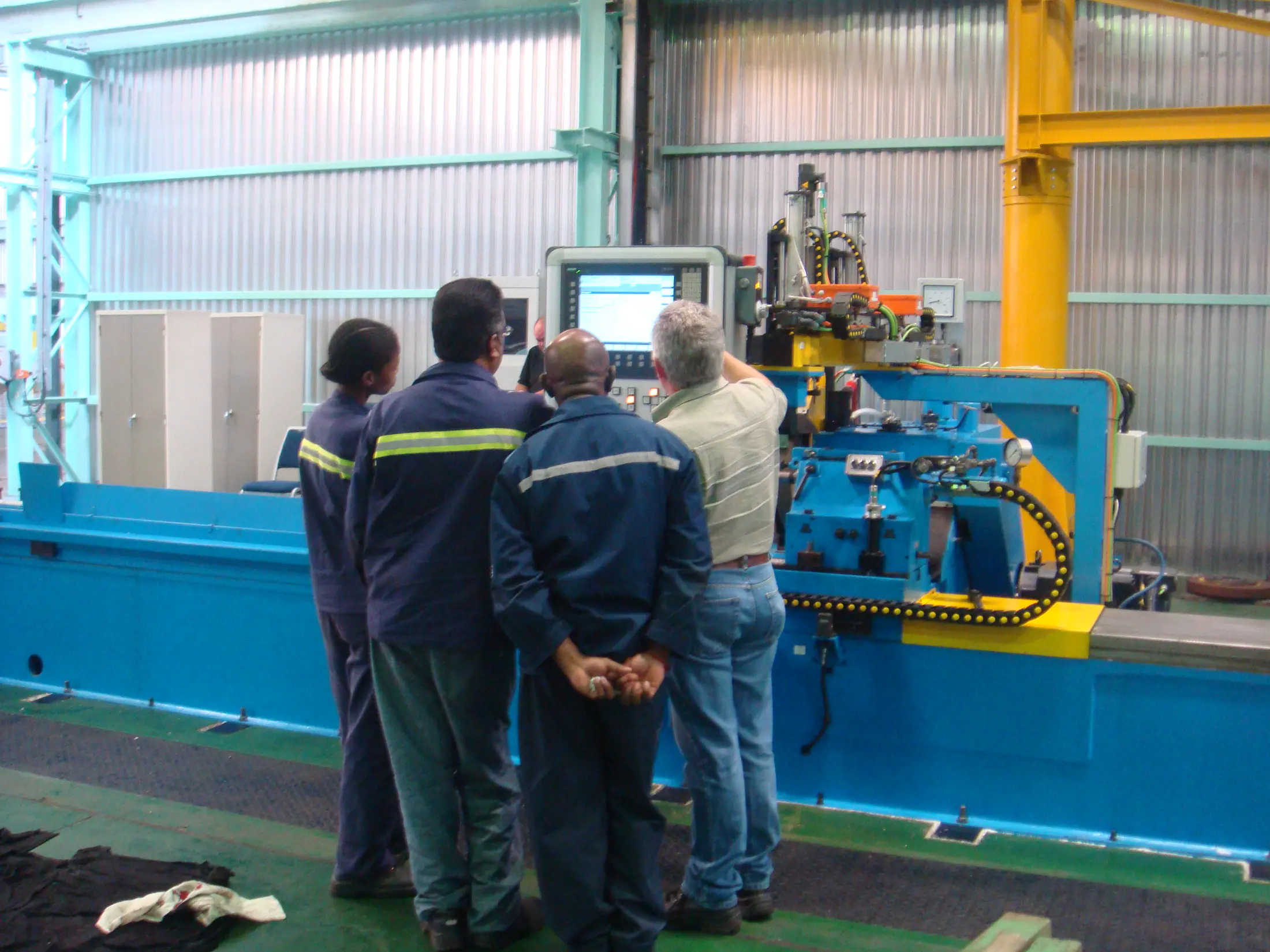 Engineering team gathered around a machine control during commissioning