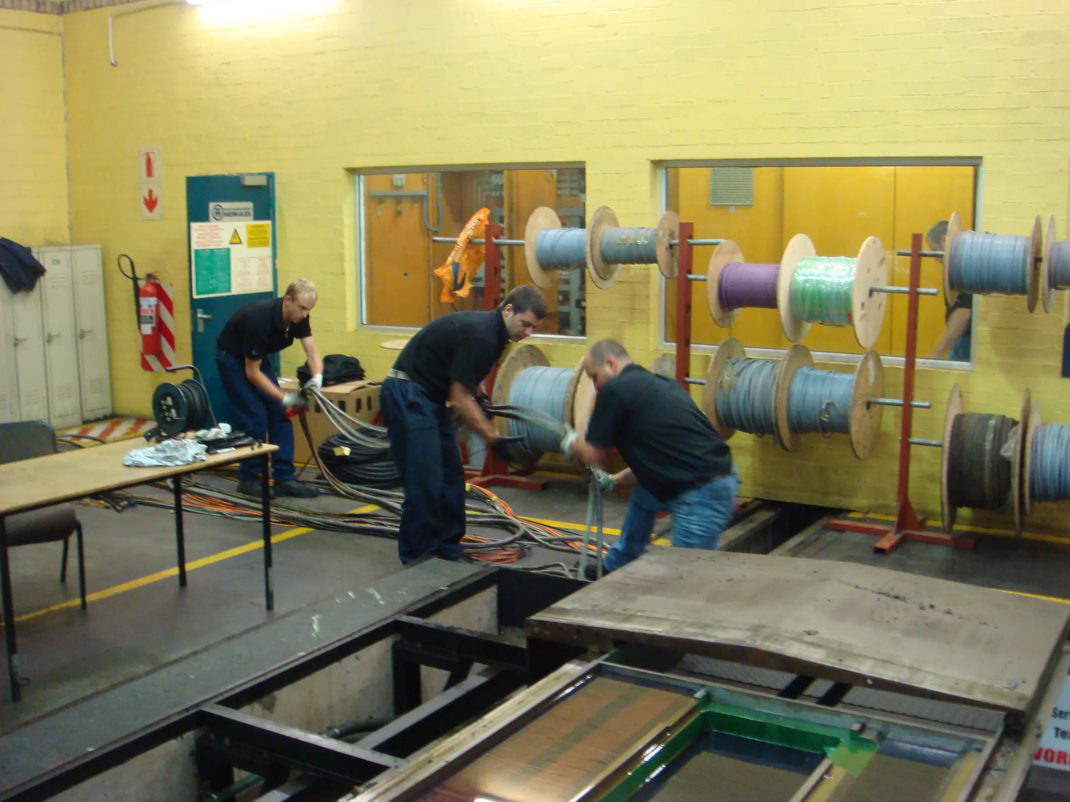 Technicians routing machine cables during electrical installation