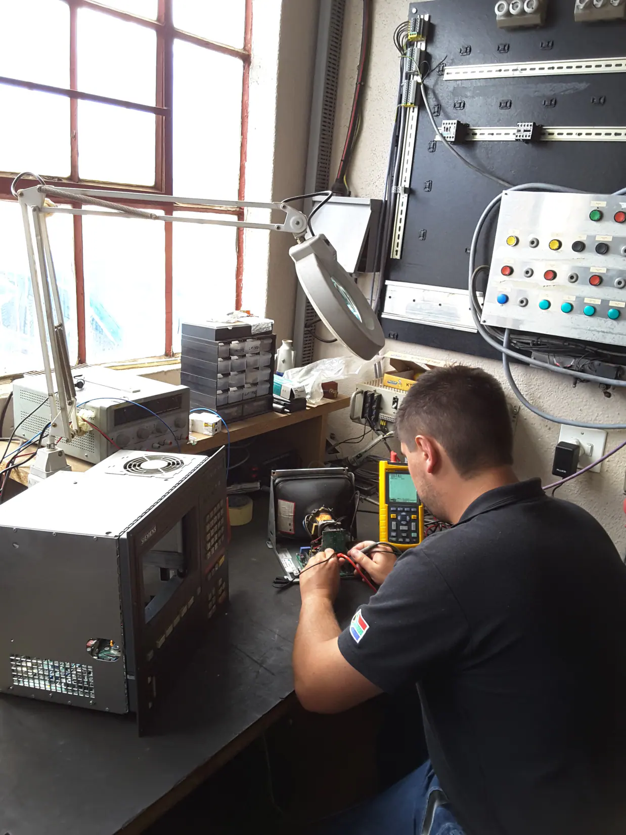 Technician bench-testing an industrial CNC control