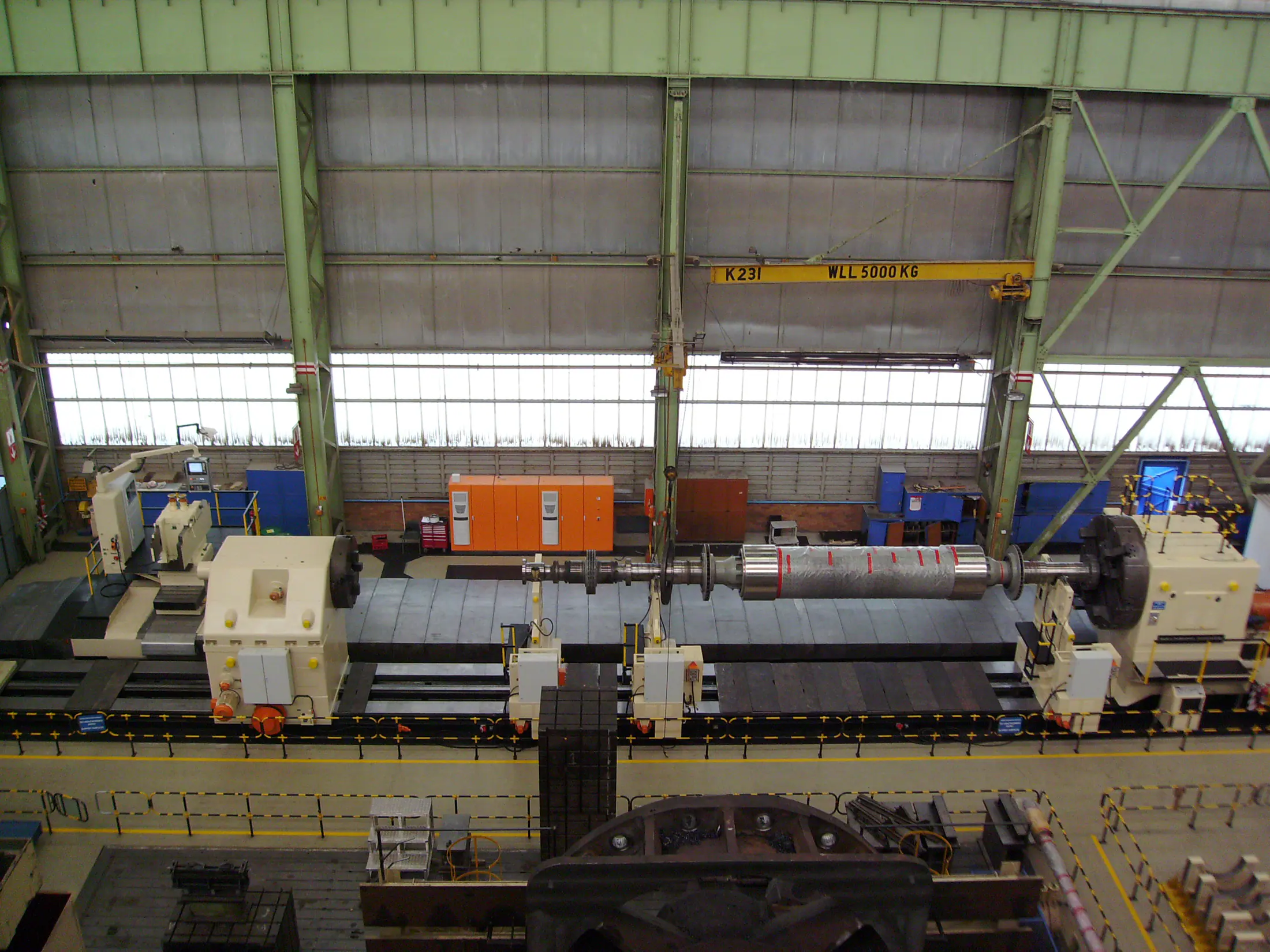 Large roll-turning machine spanning a heavy industrial bay